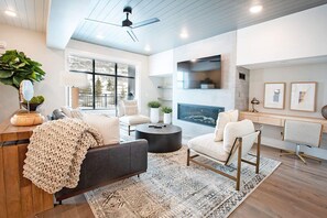 A modern living room with a sofa, armchairs, a coffee table, and a fireplace. - Large Group Penthouse w/ Game Lounge (Heber City)
