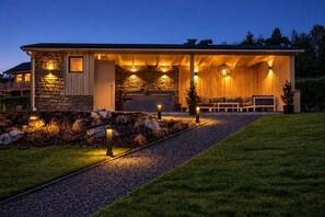 A modern house with a stone facade, a covered porch, and a well-lit outdoor seating area. - VALENTINA LODGE – Luxury vacation home near Durbuy with a spa area and game room (Durbuy)