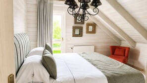 A bedroom with a bed, a chair, a radiator, and a window. - VALENTINA LODGE – Luxury vacation home near Durbuy with a spa area and game room (Durbuy)