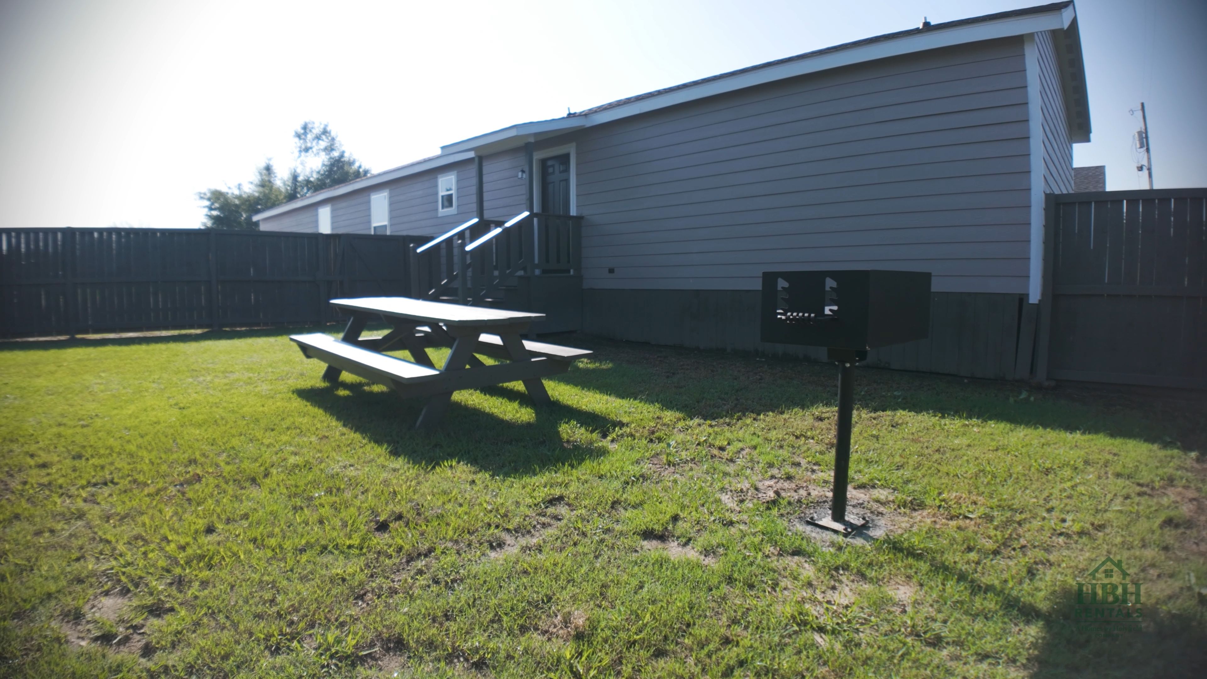A backyard with a picnic table and a mailbox.