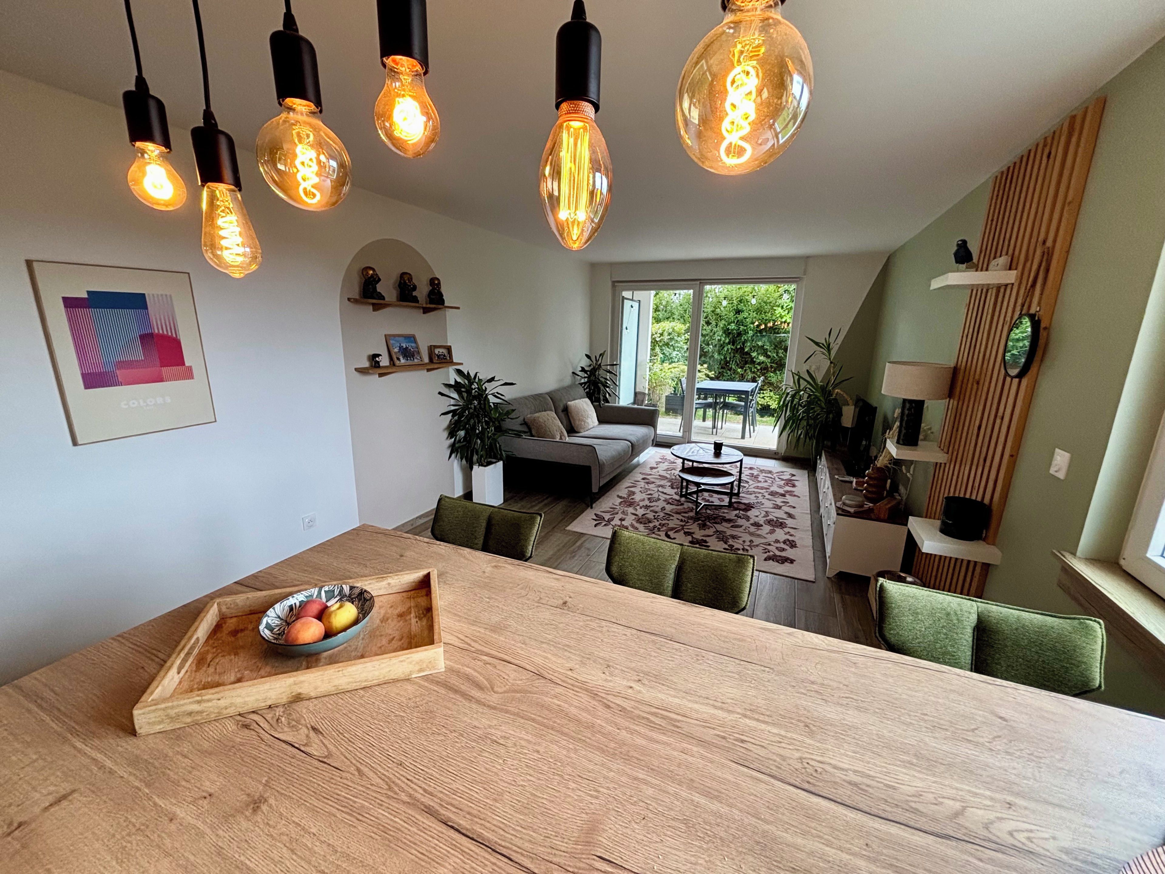 Un espace de vie moderne comprenant un coin repas, un canapé et une vue sur l’extérieur.