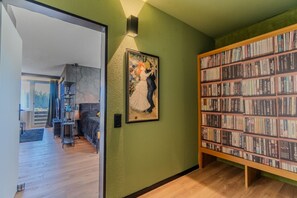 A room with a green wall, a bookshelf filled with books, and a framed picture.