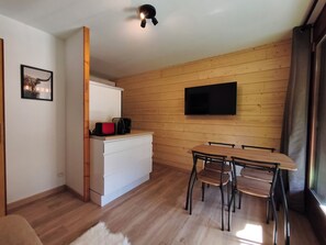 A modern kitchen with a white countertop, a black coffee maker, and a red object. - Renovated 1-Bedroom Apartment Near the Centre (La Clusaz)