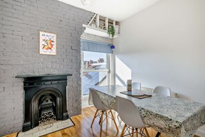 A dining area with a table, chairs, and a fireplace. - Host & Stay | Indigo Snug (Cromer)