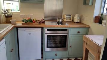 A kitchen with a dishwasher, oven, and a window with a view.
