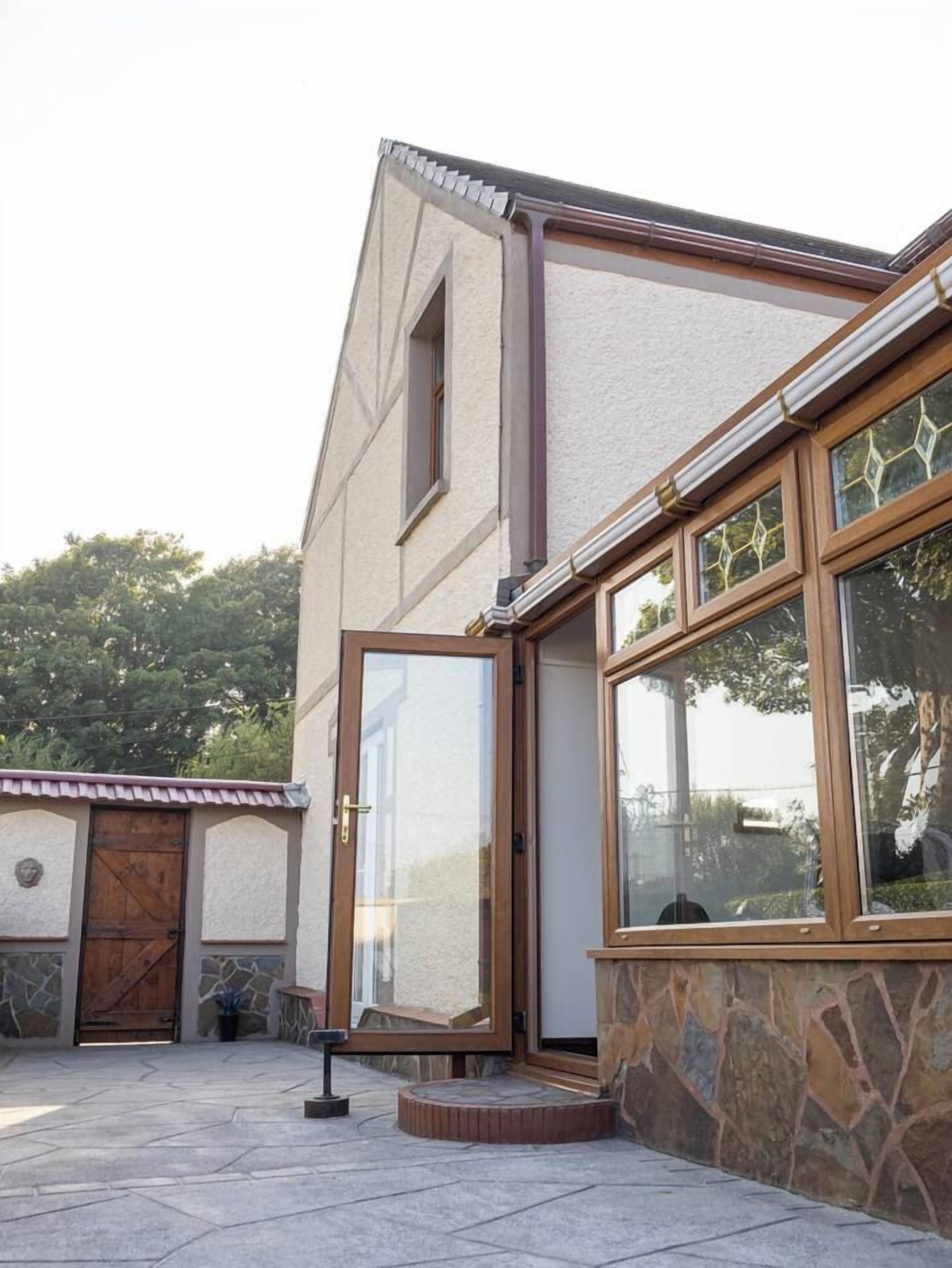 A building with a stone facade, a wooden door, and a window with a metal frame.
