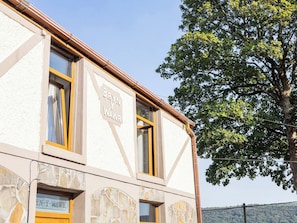 A building with a sign reading 'BYN Y WAWR' and a stone facade.
