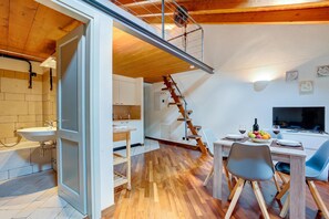 A modern kitchen with wooden flooring, a built-in sink, and a staircase leading to an upper level. - Historic Palazzo Gritti - Lugano Lakefront Stay - Vaniglia, Morcote, Switzerland (Morcote)