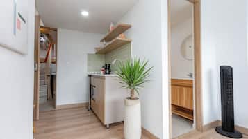 A modern kitchen with a central island, a built-in oven, and a coffee machine.