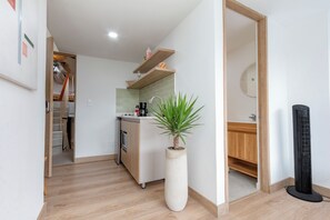 Een moderne keuken met een centraal eiland, een inbouwoven en een koffieapparaat.