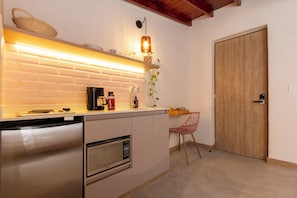 A compact kitchen with a built-in dishwasher, a coffee maker, and a microwave. - Casa Clarita (Medellín)
