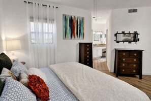 A bedroom with a bed, a dresser, a mirror, and a window with sheer curtains. - Catalina Cozy, Foothills Retreat with Screened Patio (Tucson)