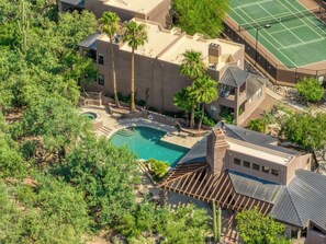 An aerial view of a residential property with a swimming pool, multiple buildings, and surrounding vegetation. - Catalina Cozy, Foothills Retreat with Screened Patio (Tucson)