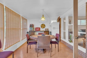 A dining area with a table, chairs, and a refrigerator. - Atomic Agave, Mid-Century Tucson Retreat (Tucson)