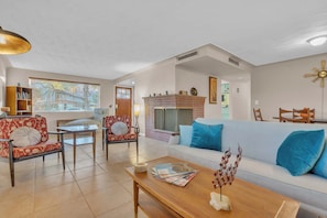 A living room with a sofa, chairs, a coffee table, and a fireplace. - Atomic Agave, Mid-Century Tucson Retreat (Tucson)
