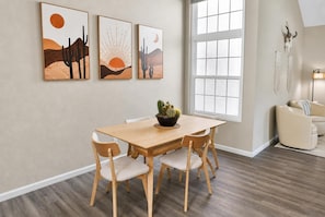 Ein Essbereich mit Holztisch und Stühlen, einer Sukkulenten-Mittelstück und Wandkunst im Wüstendesign.