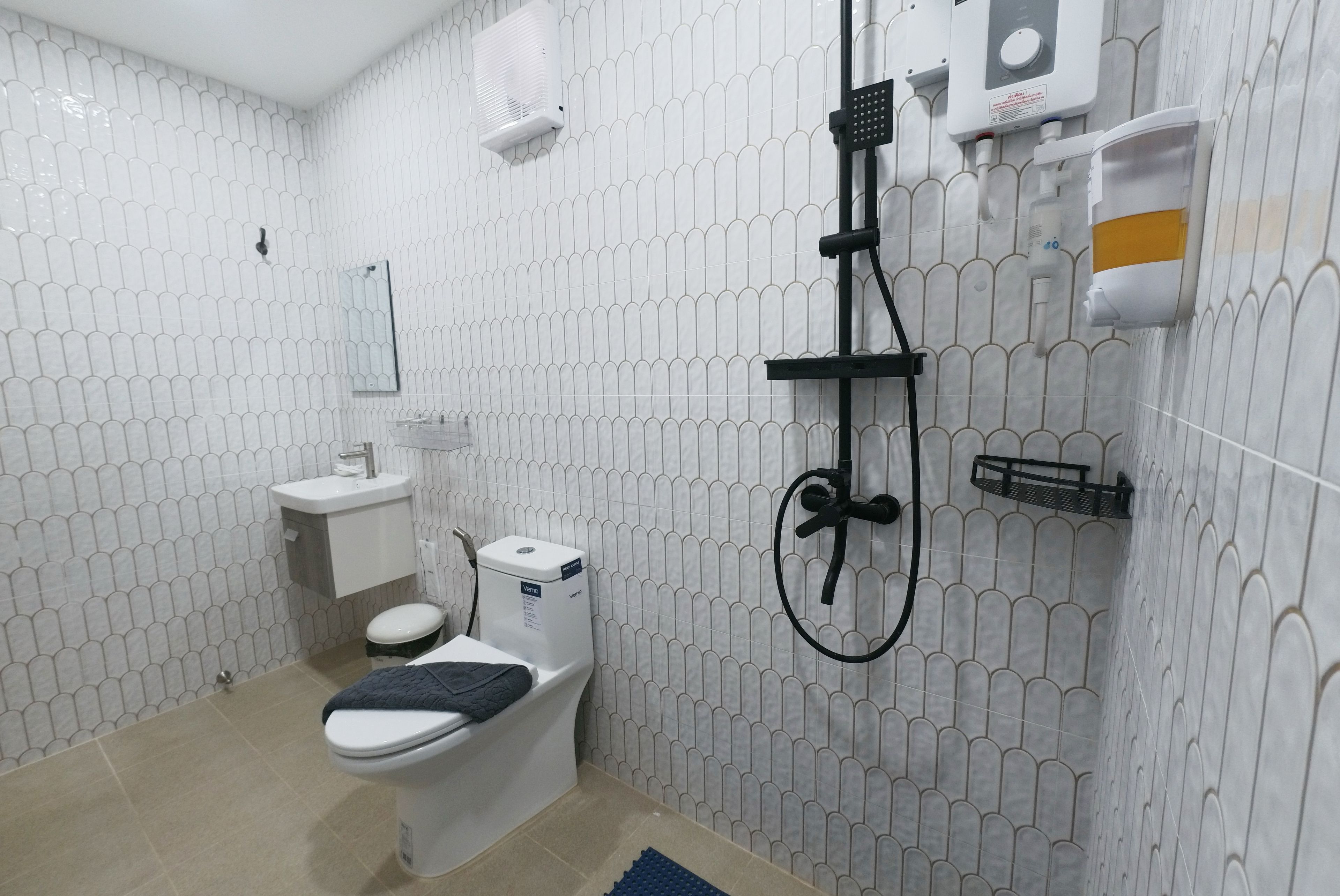 Un baño con inodoro, lavabo y ducha.
