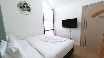 Una camera da letto con un letto, una televisione a parete e un armadio.