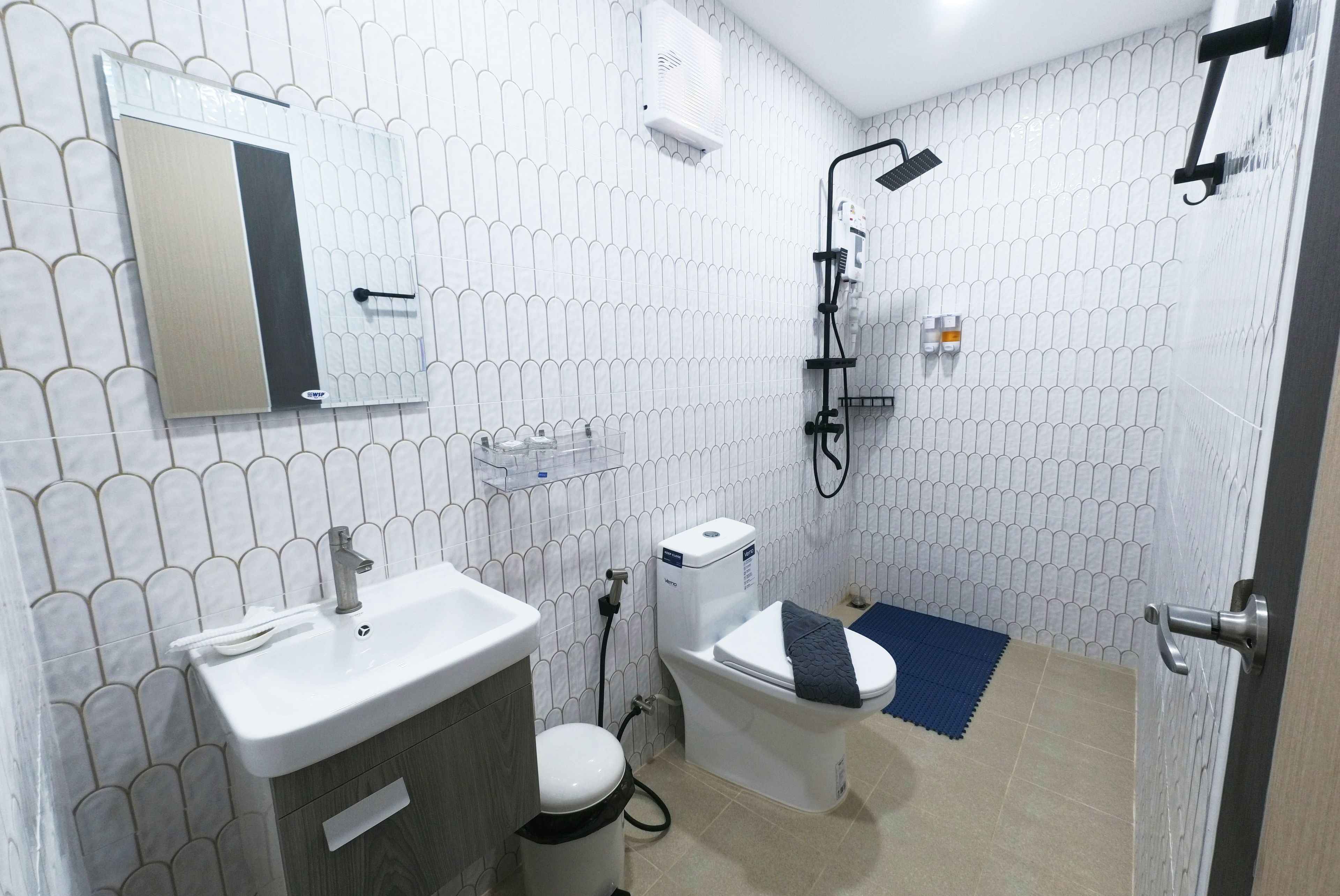 A bathroom with a toilet, sink, and shower.