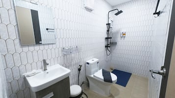 A bathroom with a toilet, sink, and shower.