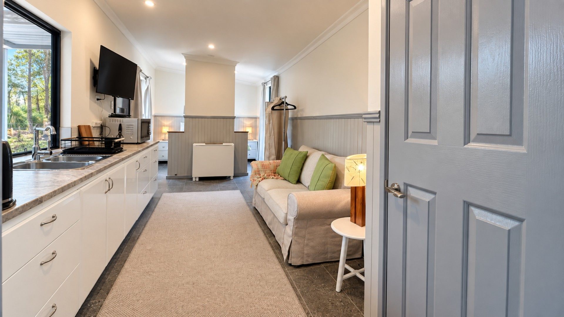 A modern kitchen with a built-in oven, a microwave, and a sink.