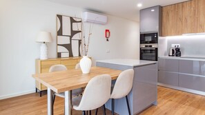 Eine moderne Küche mit Backofen, Kaffeemaschine und kleinem Kühlschrank.