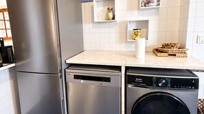 A compact kitchen with a stainless steel refrigerator, a dishwasher, and a washing machine. - Casa da Murtinheira by LovelyStay (Quiaios)