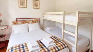 A bunk bed room with a red metal frame, white bedding, and a checkered blanket. - Casa da Murtinheira by LovelyStay (Quiaios)