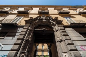 An ornate architectural entrance with a central archway, flanked by balconies and windows. - Living Filomarino - Appartamento 2 (Naples)