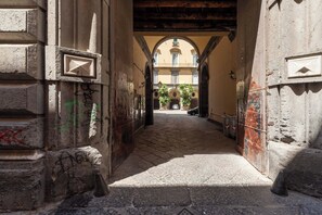 A stone-paved alleyway with arched doorways and graffiti. - Living Filomarino - Appartamento 2 (Naples)