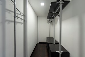 A corridor with a coat rack, a hanging garment, and a bench. - Living Filomarino - Appartamento 2 (Naples)