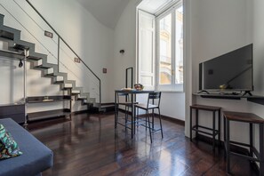A modern interior with a staircase, a dining area, and a large window. - Living Filomarino - Studio 3 (Naples)