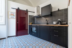 A kitchen with a stove, oven, and a coffee maker. - Living Filomarino Collection (Naples)