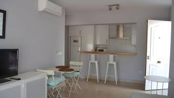 A compact living space with a kitchenette, a dining area, and a seating area.
