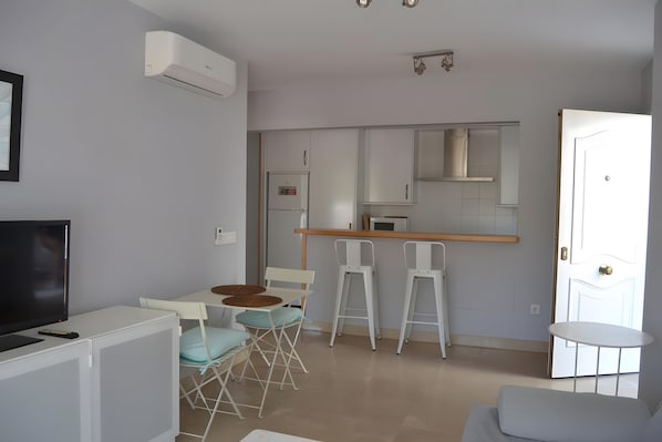 A compact living space with a kitchenette, a dining area, and a seating area.
