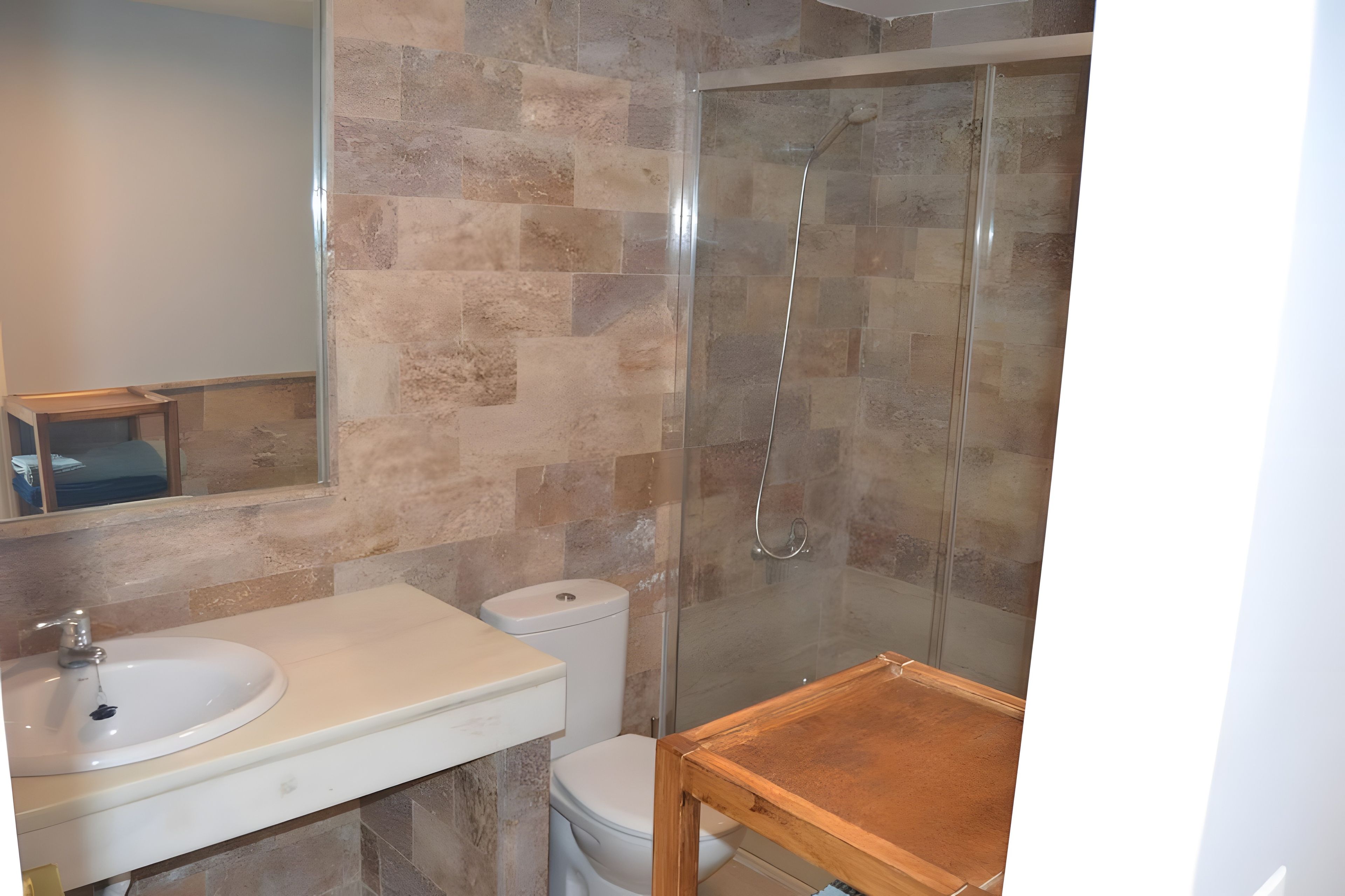 Un baño con ducha, lavabo e inodoro.