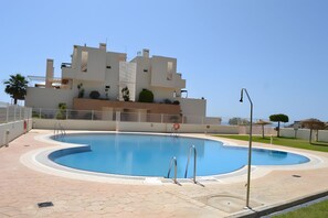 A swimming pool with a modern building in the background.
