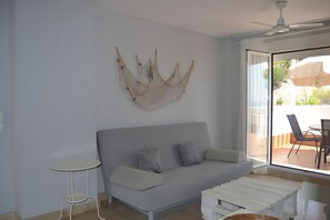 Un soggiorno moderno con un divano grigio, un tavolino rotondo e un elemento decorativo a parete.