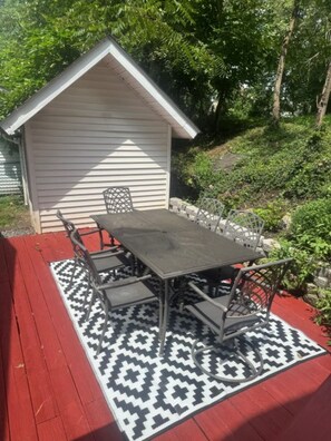 A patio with a table and chairs, a patterned rug, and a small shed. - The Grateful Trail House-Garcia A 2-bdrm apartment in Mountain Cumberland, MD. (Cumberland)