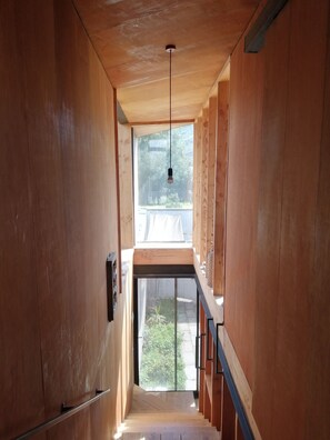 Un interior de madera con una escalera que lleva a un balcón.