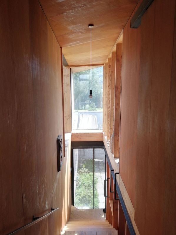 A wooden interior with a staircase leading to a balcony.