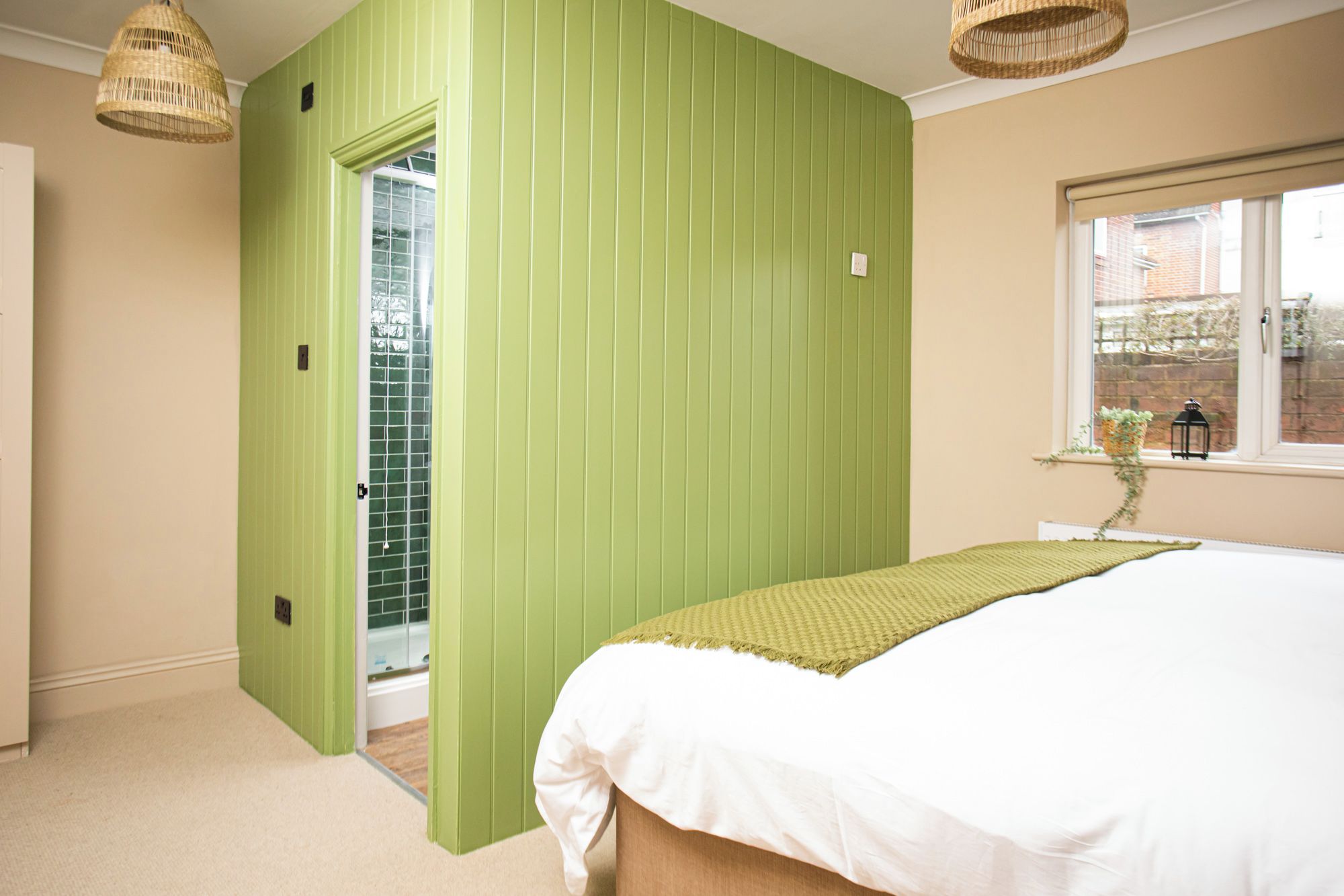 Un dormitorio con una cama, una ventana y una puerta que da a un baño.