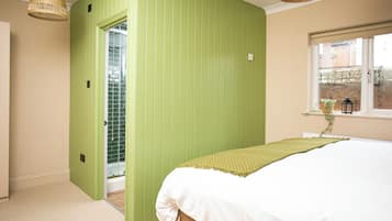 Un dormitorio con una cama, una ventana y una puerta que da a un baño.
