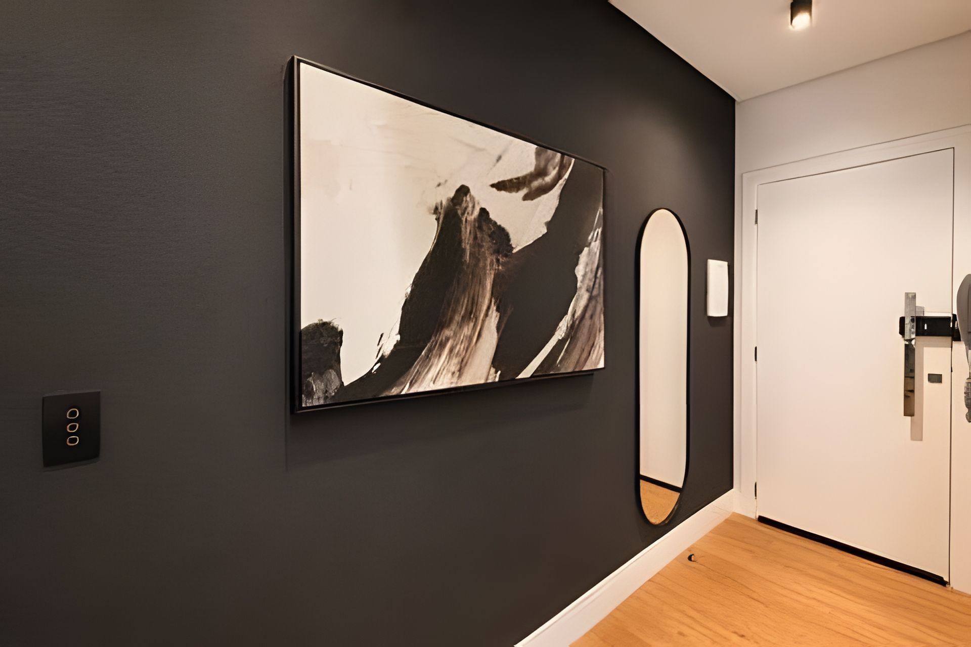 A hotel room with a large abstract painting on the wall, a mirror, and a door.
