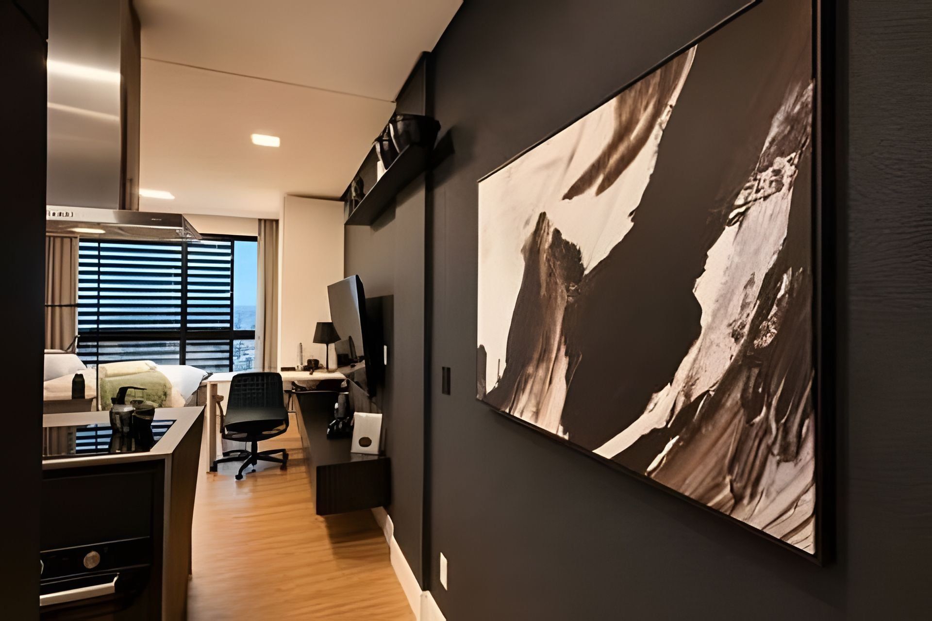 A modern hotel room with a large abstract painting, a desk with a chair, and a view of the outdoors through the window.