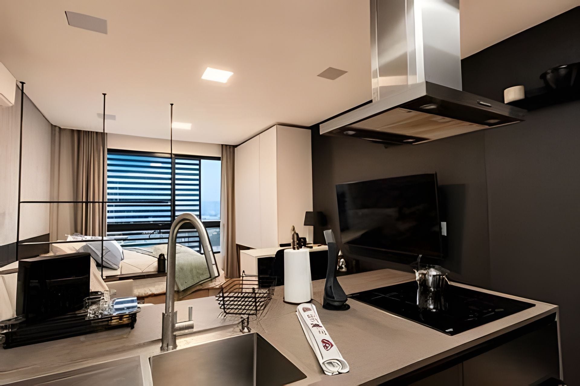 A modern kitchen with a built-in stove, a flat-screen TV, and a dining area with a table and chairs.