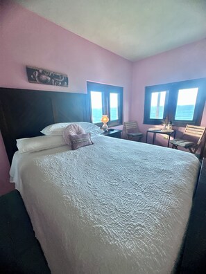 A hotel room with a large bed, a desk, a chair, and a window with a view of the sea. - You found a unicorn ~hidden beach cottage~The LoveNest~Rincón  (Rincón)