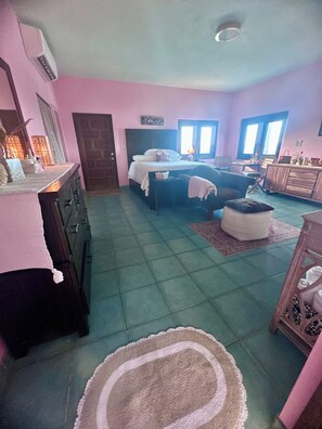 A bedroom with a bed, dresser, and a desk with a chair.