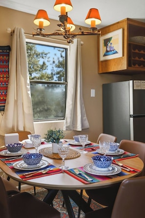 A dining area with a round table set for four, surrounded by chairs. - Amethyst Ridge- A True Gem! (Prescott)
