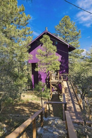 A purple building with a wooden deck and stairs leading to a covered area. - Amethyst Ridge- A True Gem! (Prescott)